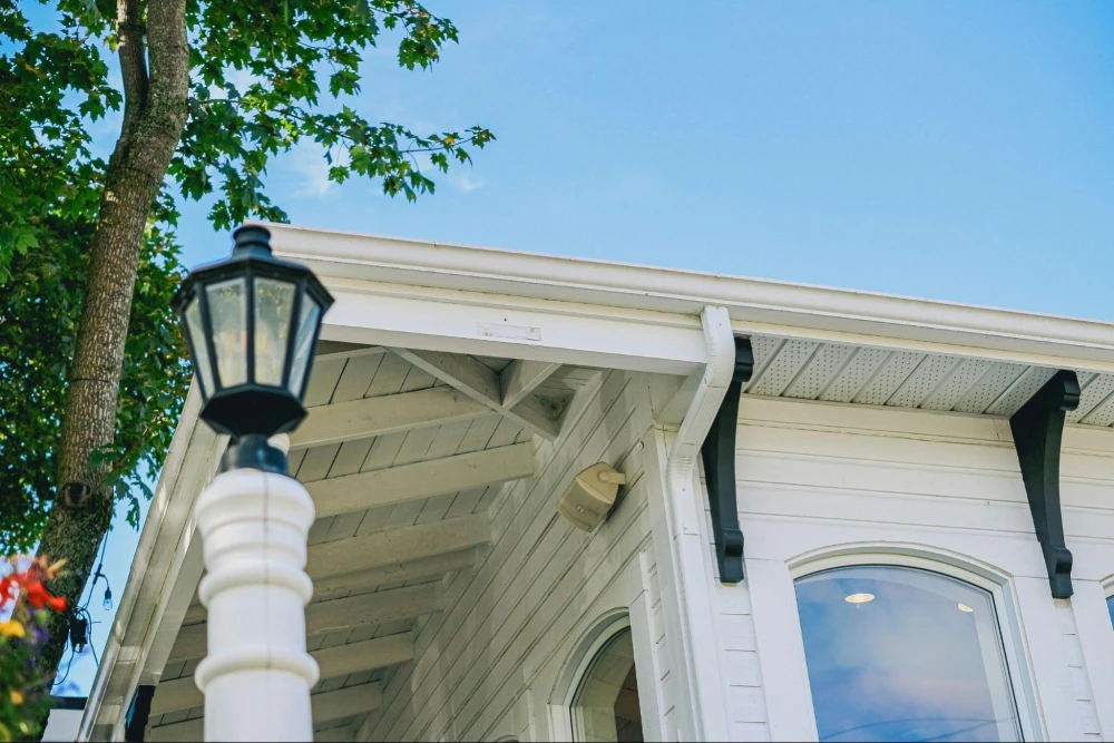Home exterior with outdoor light, soffit, and gutter